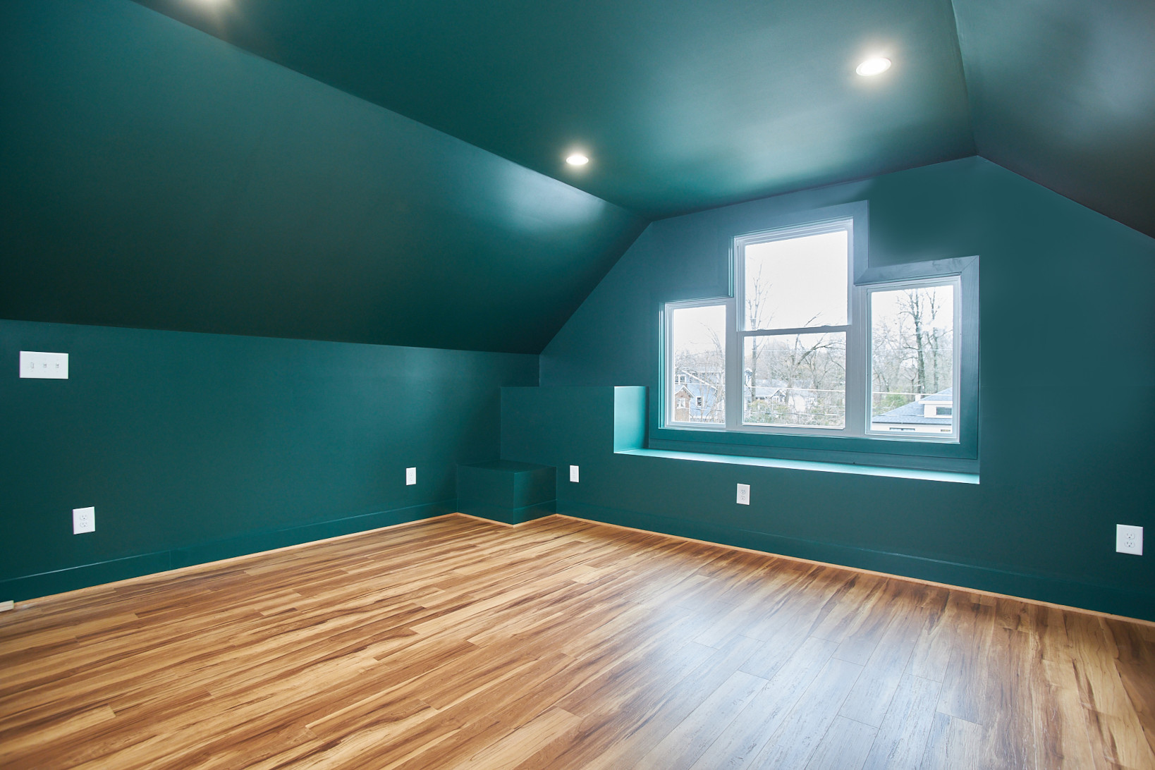 Renovated attic with hardwood floors and green walls